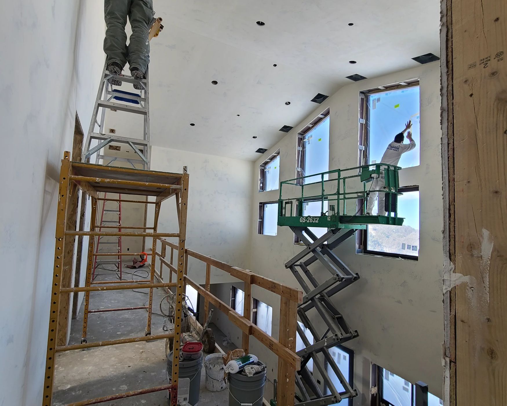 Scaffold and scissor lift set up in a two-story great room before finishing