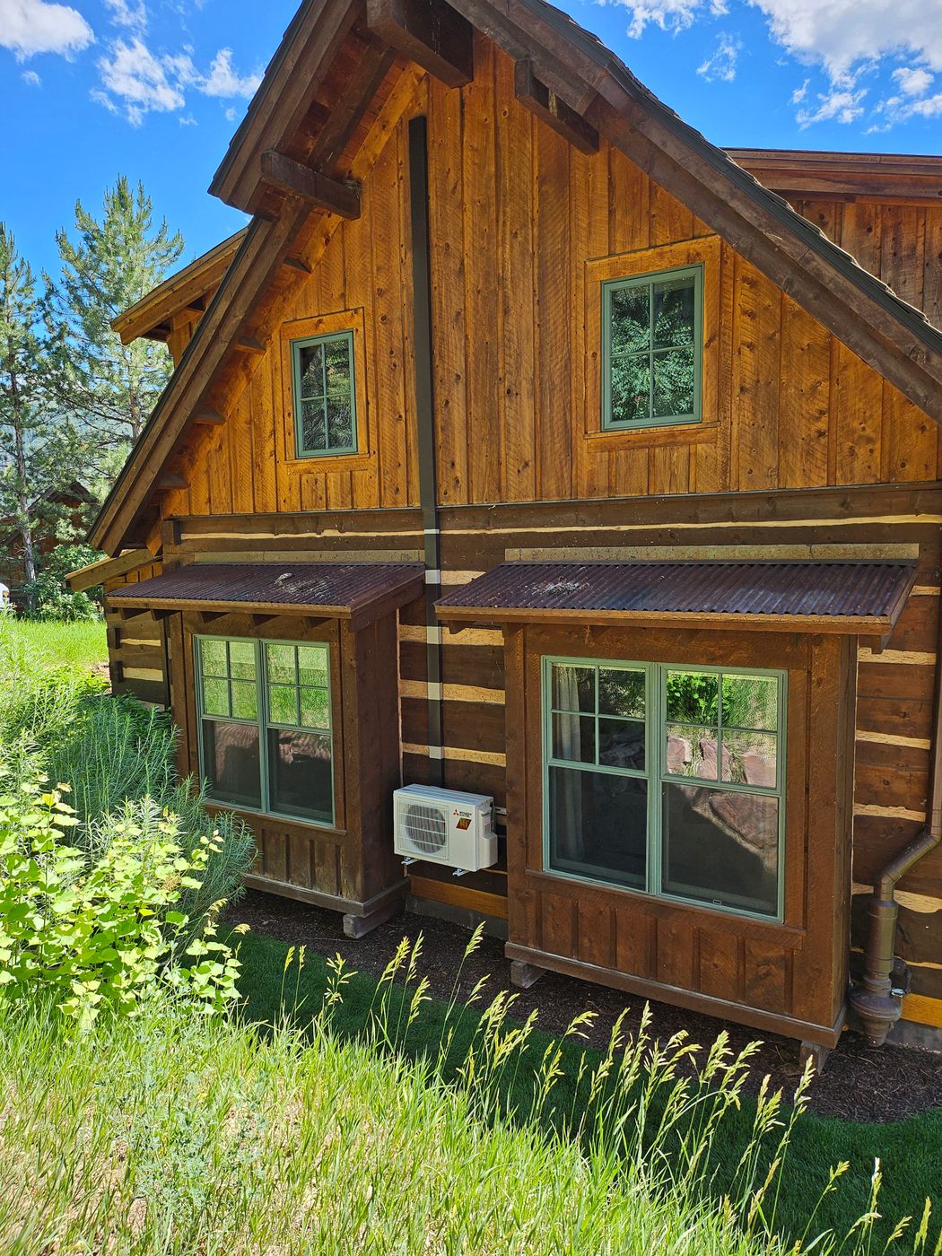 Log home with a mini-split outdoor unit set below a window