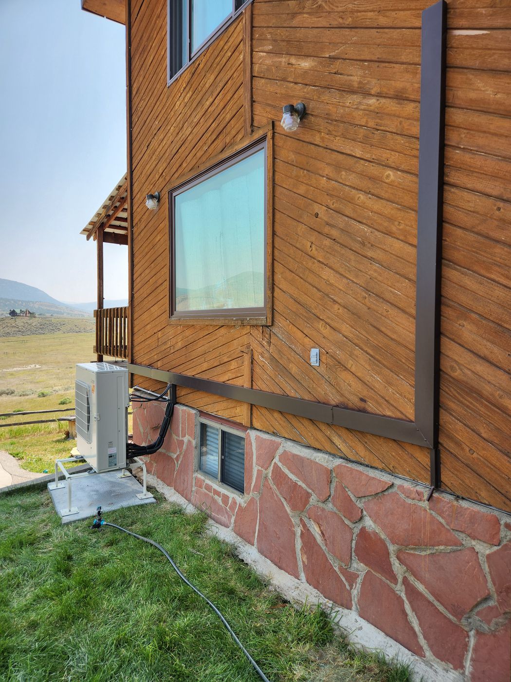 Line hide channel painted to match the trim on a cedar-sided home with a valley view