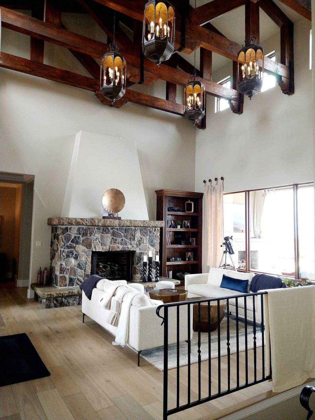 Finished great room with timber trusses, stone fireplace and white oak floors
