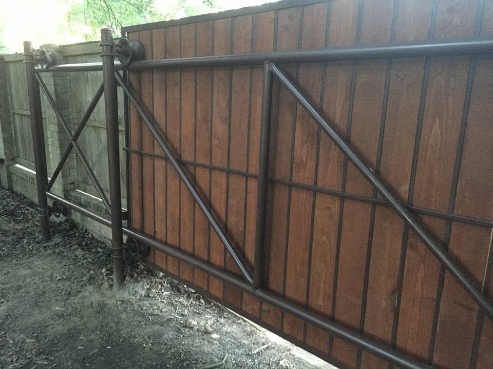 Stained wood gate on a black steel frame