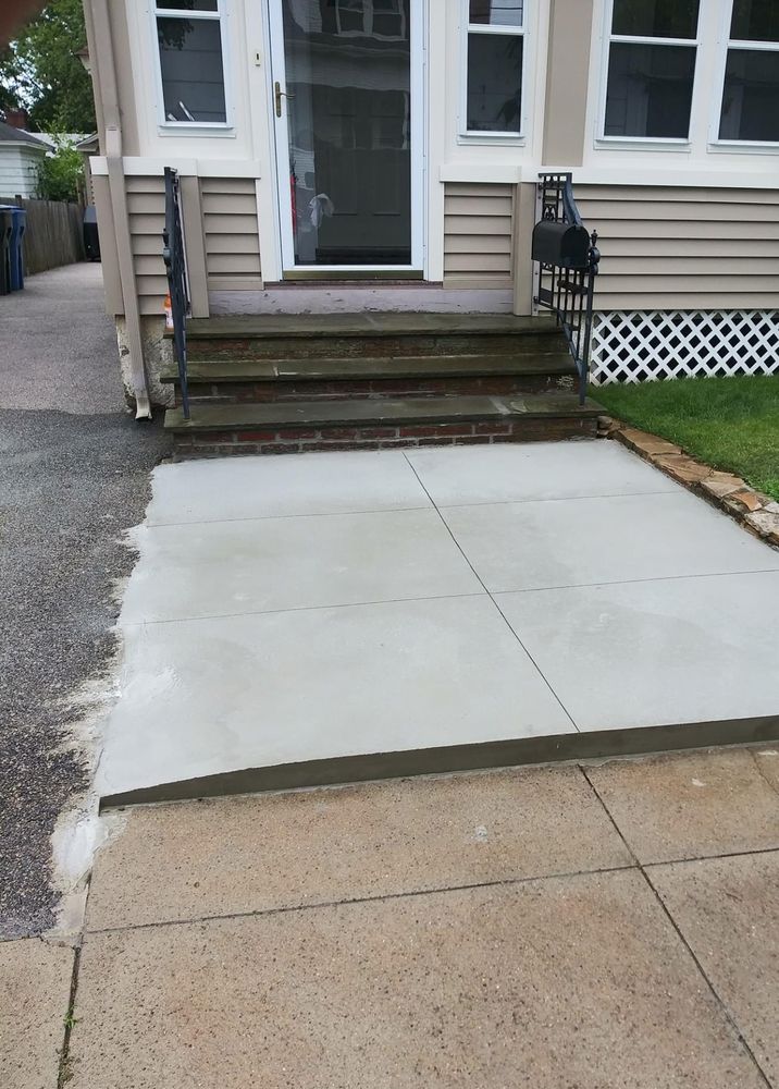 The same front walkway rebuilt as a clean new concrete walk and landing