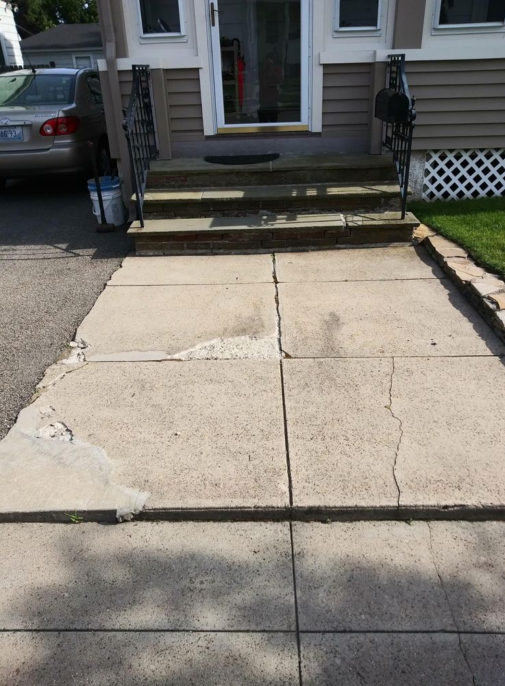 Old cracked and stained concrete walkway and steps in front of a house before replacement