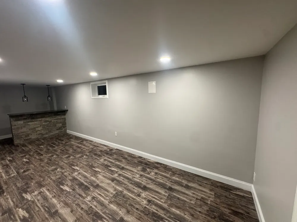 After: the finished basement with new plank flooring