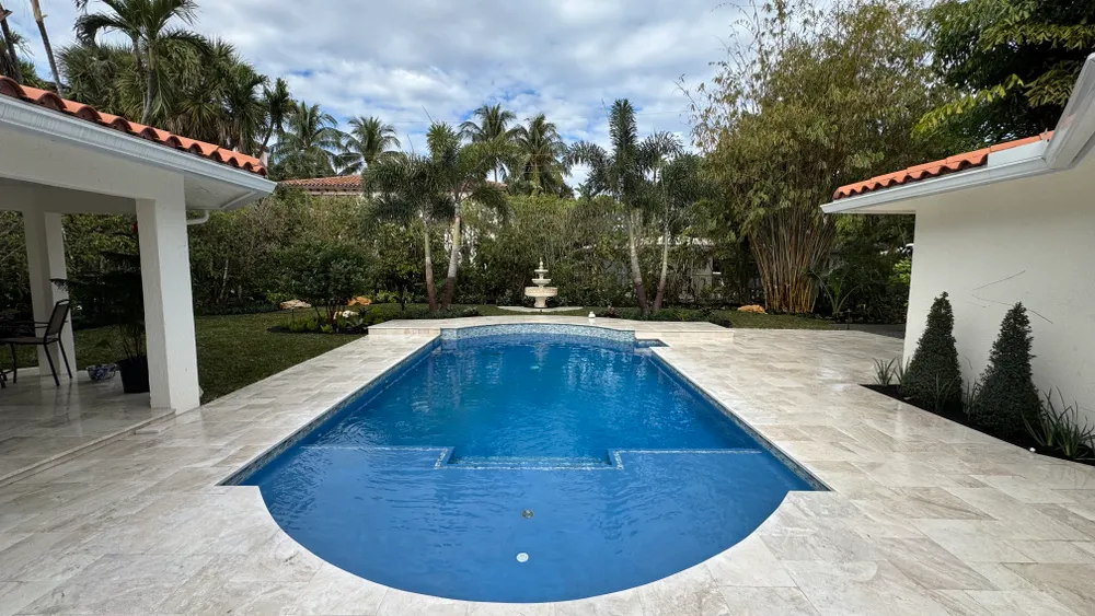 Backyard pool, fountain and palms in daylight