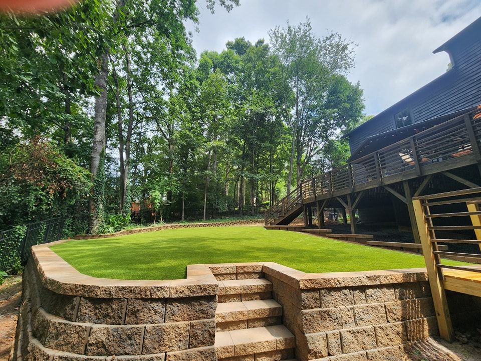 Our Retaining Wall Construction service provides durable and aesthetically pleasing solutions to prevent soil erosion, enhance landscape stability, and create functional outdoor spaces tailored to your property's unique needs. for Elite Turfs in Mount Pleasant, NC