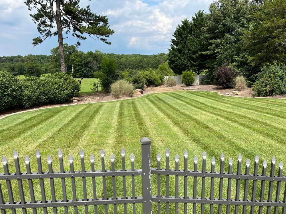 Our Lawn Aeration service improves soil structure by creating small holes to allow air, water, and nutrients to penetrate deep into the roots, promoting a healthy and lush lawn. for Red Clay Landscapers in Sophia, NC