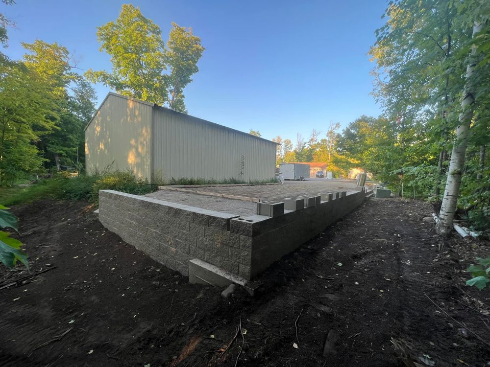 Our Stone Wall Installation service, a perfect complement to our sidewalk installation services, offers homeowners durable and aesthetically pleasing solutions for enhancing property boundaries and landscape designs. for ProStar Concrete & Masonry in Onamia, MN