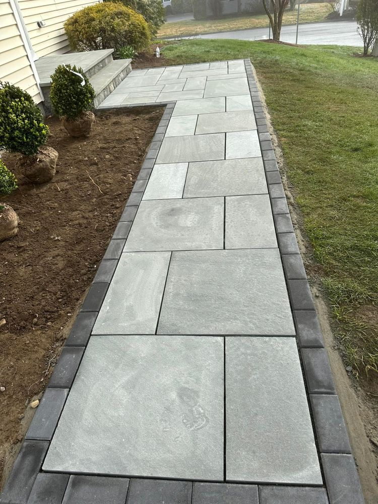 Enhance your home's outdoor appeal with our expert patio design & construction services, creating beautiful walkways and pathways that seamlessly blend functionality and aesthetic charm for a captivating landscape experience. for Willis Landscape & Masonry LLC in Newtown, CT