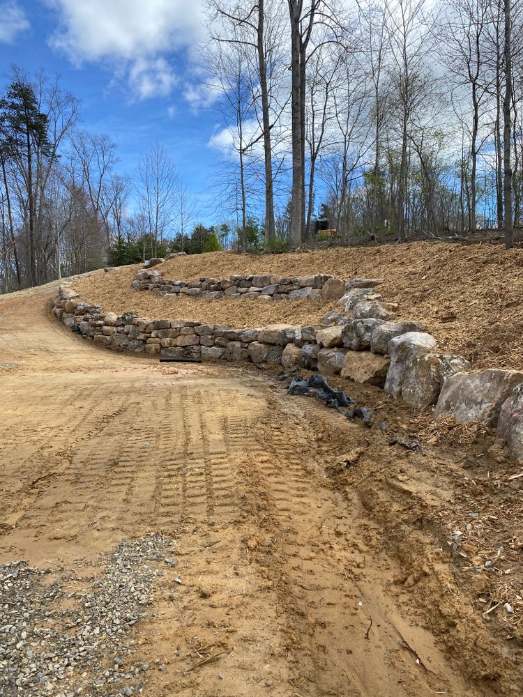 Enjoy the natural look of boulder walls while also serving an important roll to stabilize steep banks as well as make more useable space on your property. for Lanier Excavating LLC in Bedford County, VA