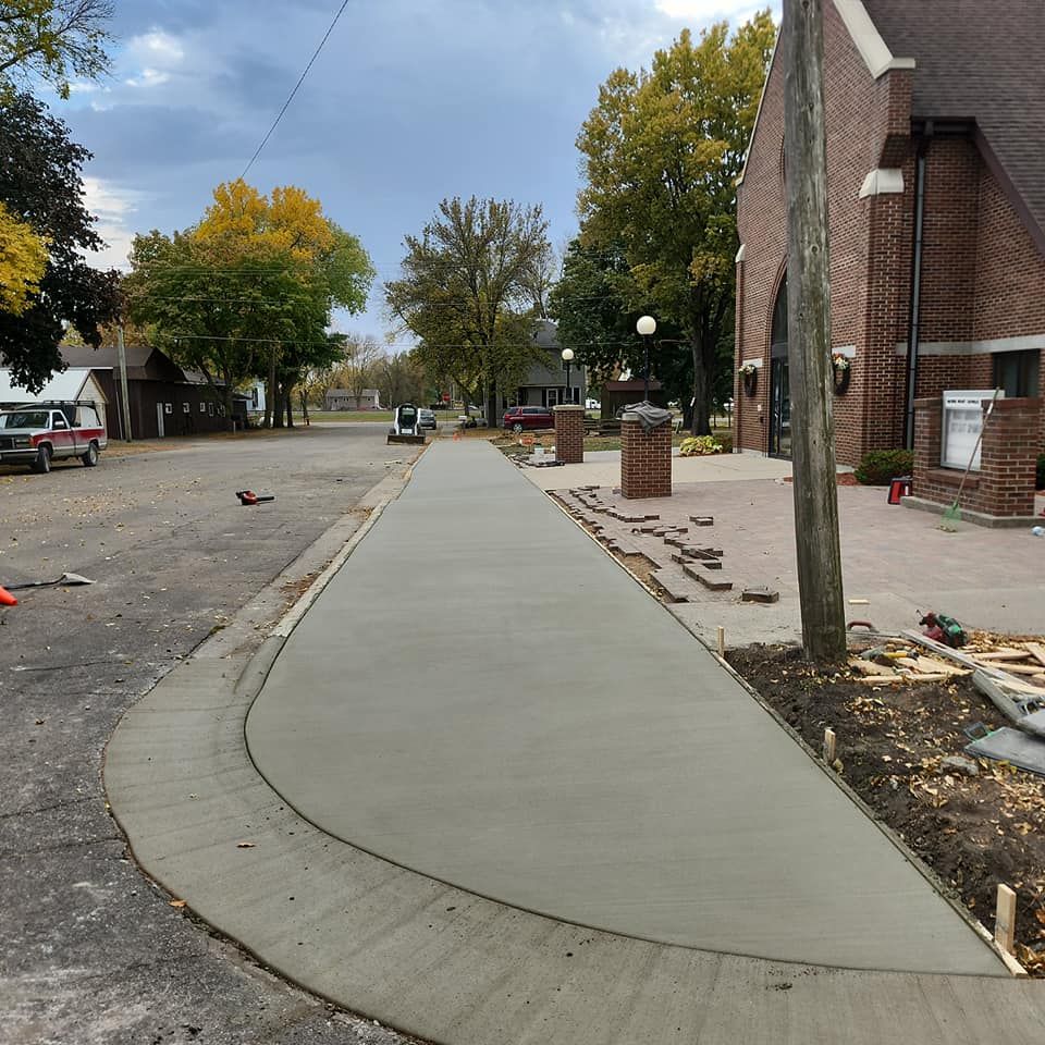 Our expert Sidewalk Installation service ensures durable, visually appealing pathways that enhance your home's curb appeal and safety. We use top-quality concrete to create custom designs tailored to fit your specific needs. for Cousins Construction in Murdock, MN