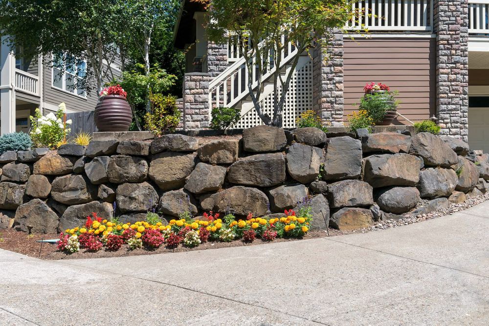 Our custom-designed retaining walls provide structural support for sloped landscapes, preventing erosion and creating functional levels of usable space in your yard while adding aesthetic appeal to your outdoor living area. for The Stone Garden in Farmington Hills, MI