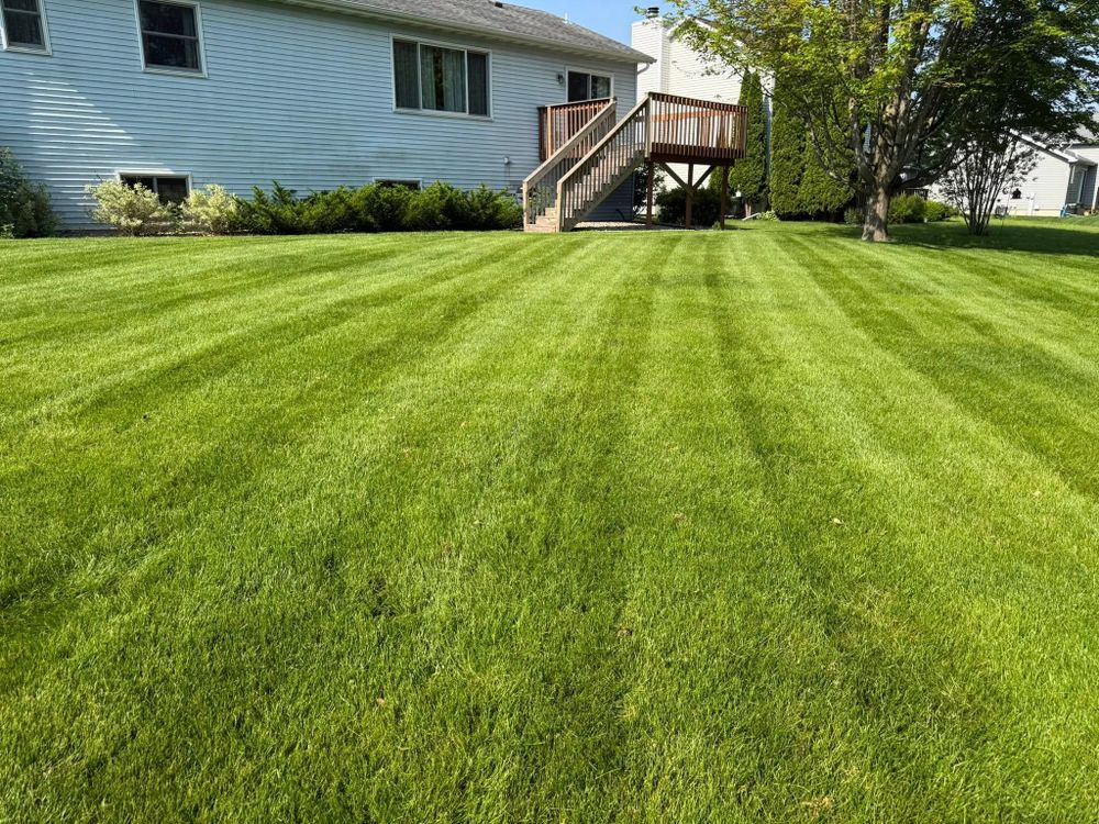 Our professional mowing service ensures a beautifully manicured lawn, enhancing your home's curb appeal with precise cutting, edging, and debris removal for a consistently pristine outdoor space year-round. for Perfect Lawn Solutions LLC in Marshall, WI