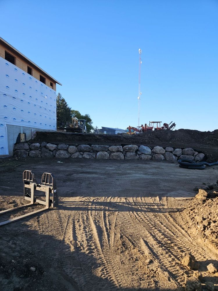 Our Boulder Walls service enhances your property by creating natural-looking and durable retaining walls using high-quality materials, expert craftsmanship, and attention to detail for long-lasting beauty and functionality. for Brownstone Grading in Perry, IA