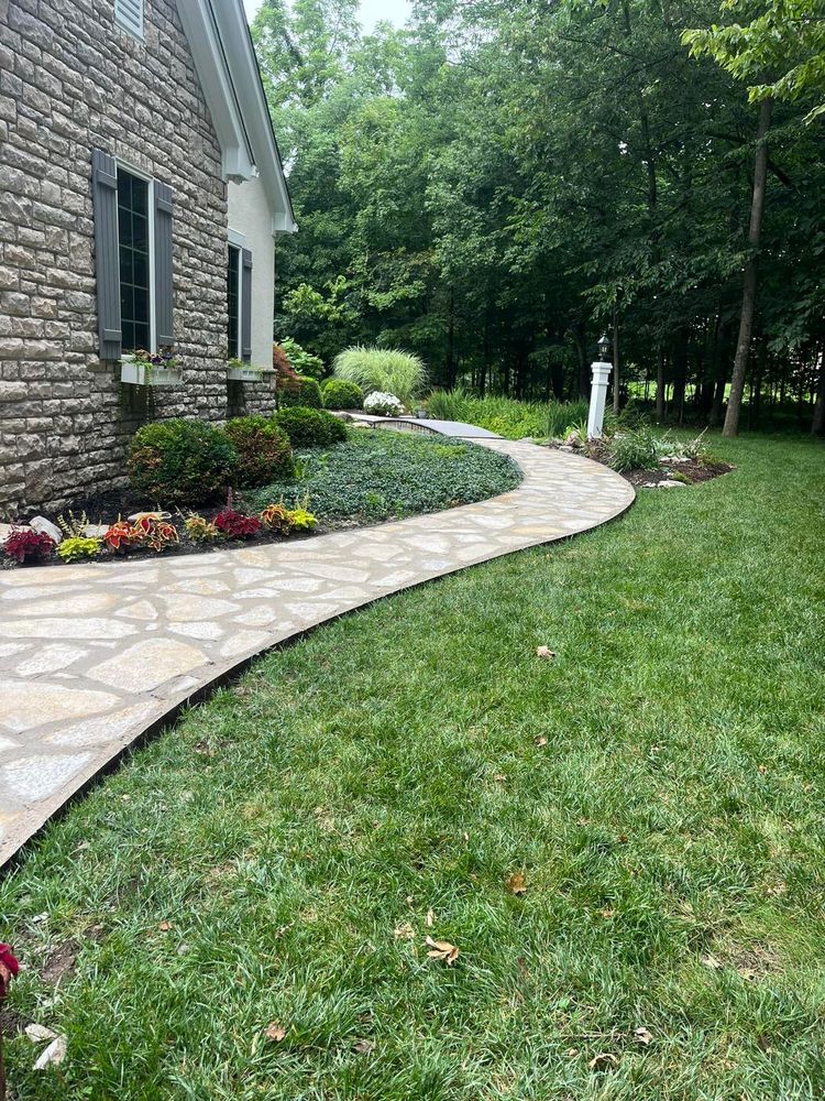 Our Flagstone Walkway Installation service offers a beautiful and durable pathway that enhances the aesthetic appeal of your outdoor space while providing a functional and inviting entryway to your home. for Higgins landscaping LLC in West Jefferson, OH