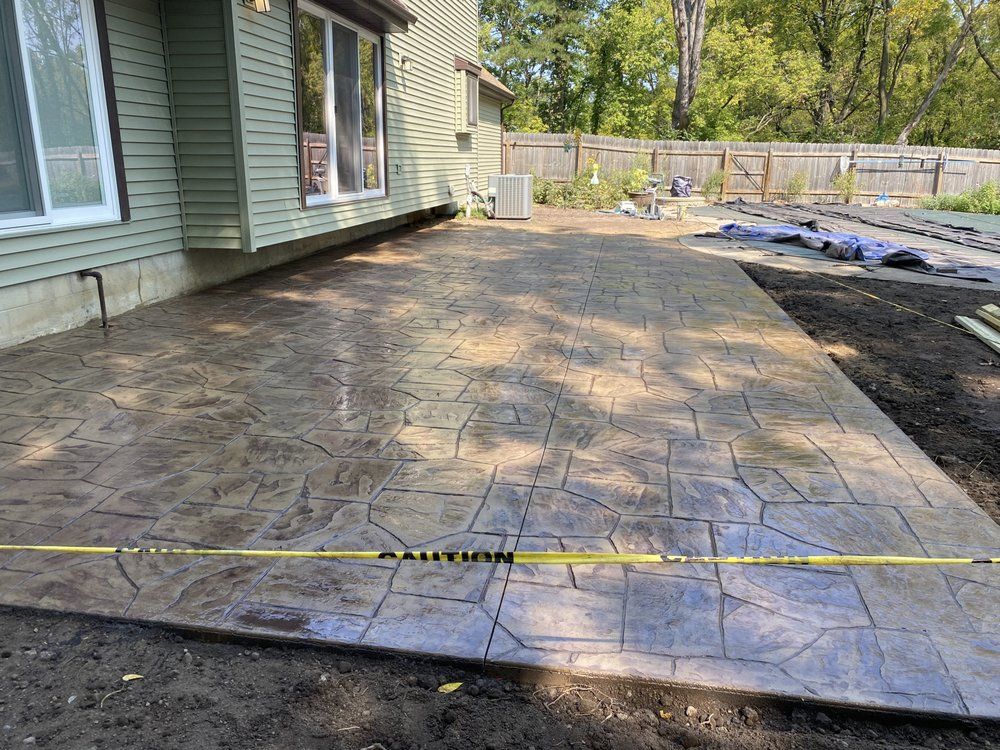 Enhance your home's aesthetics with our expert stamped concrete installation, offering a wide range of customizable patterns and colors for durable, visually appealing driveways, patios, and walkways designed to elevate any outdoor space. for JW Concrete Services LLC in Lansing, MI