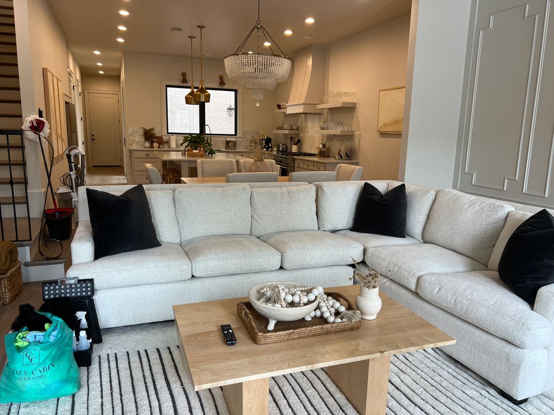 Living room with a white sectional after a clean