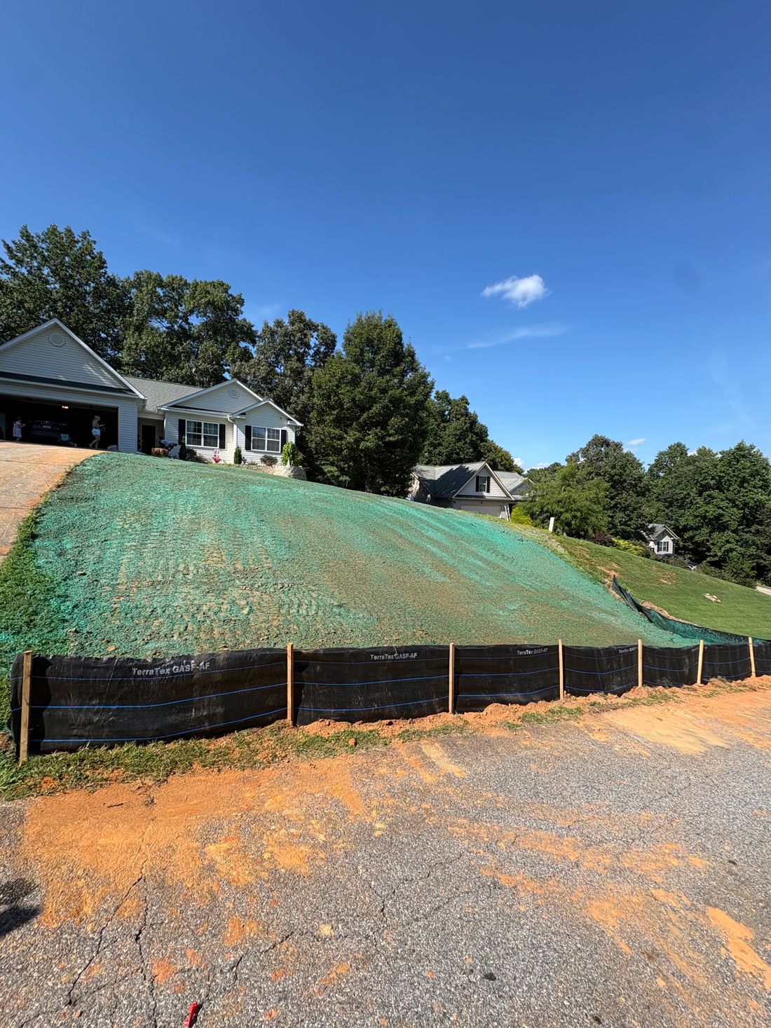 Sprayed slope with silt fence along the drive