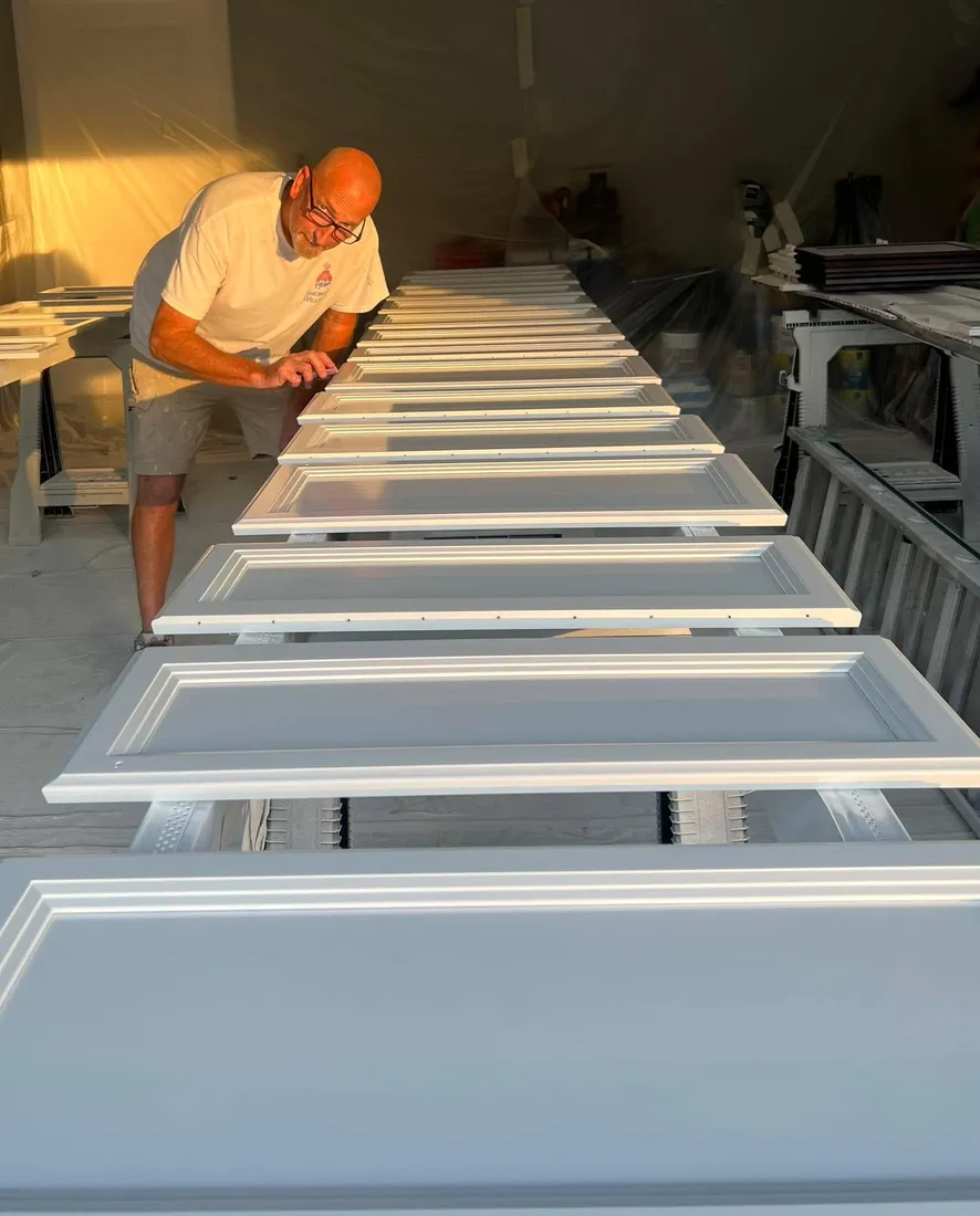 Ryan Garrity spray finishing a run of cabinet doors in the shop