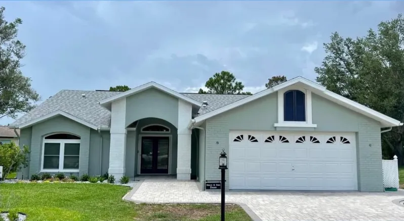 Exterior repaint on a Pinellas County home with fresh stucco and white trim