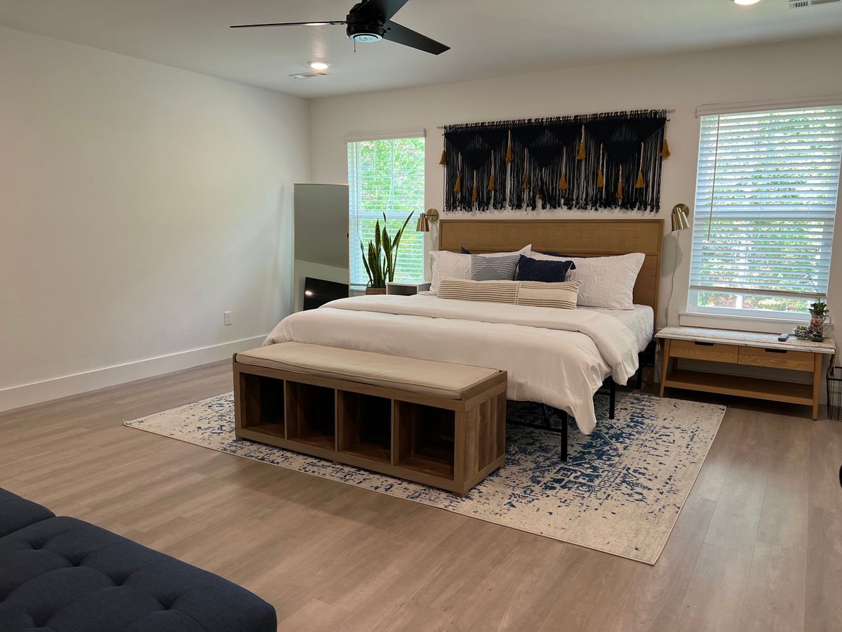 Bedroom with a made bed and clean floors after a house cleaning