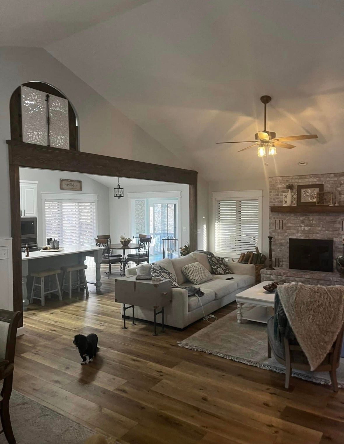 Great room with a fireplace and vaulted ceiling after a clean