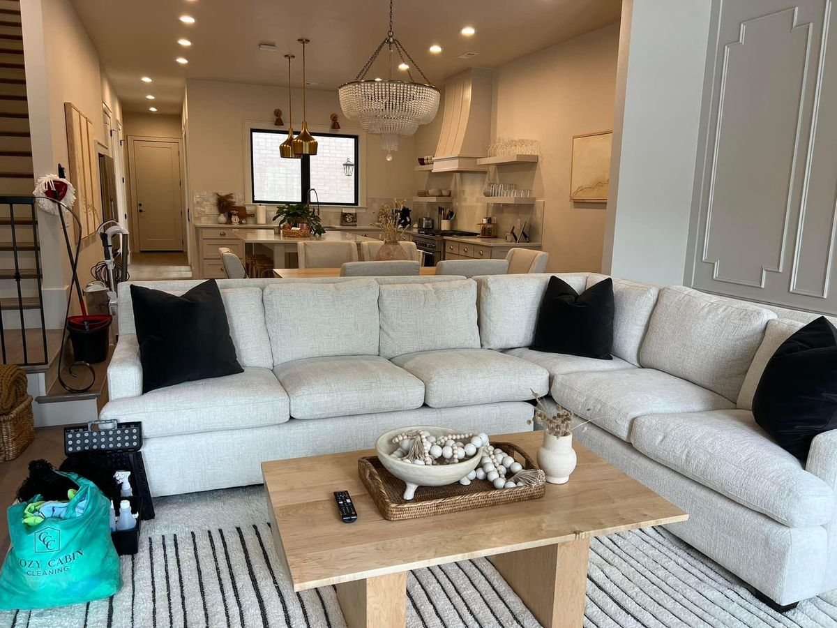 Living room with a white sectional after a clean