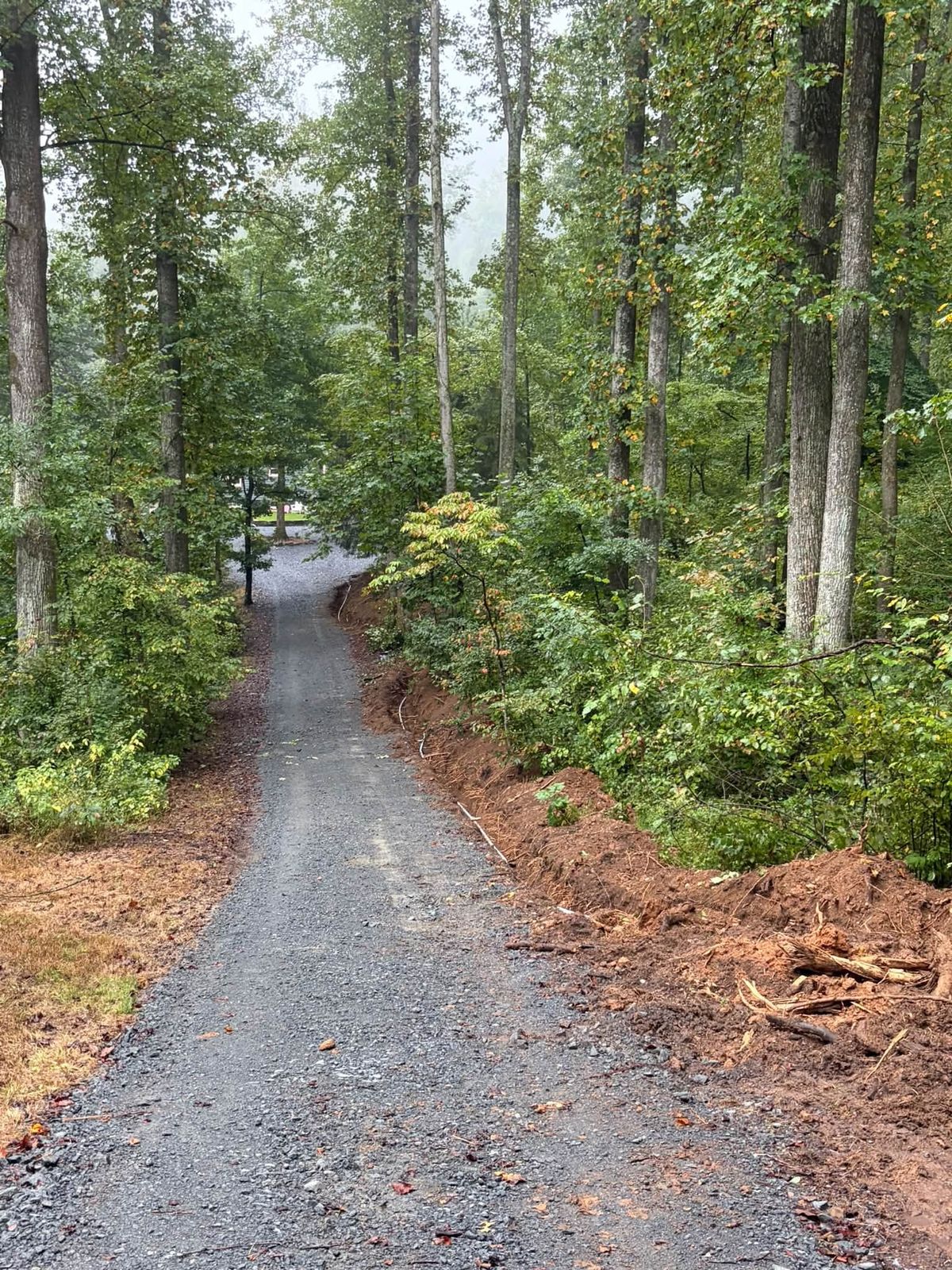 Private gravel road through the woods after regrading