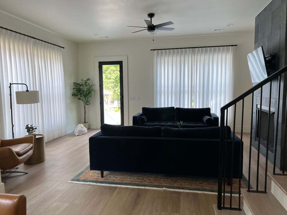 Living room with tall windows and a staircase after a clean