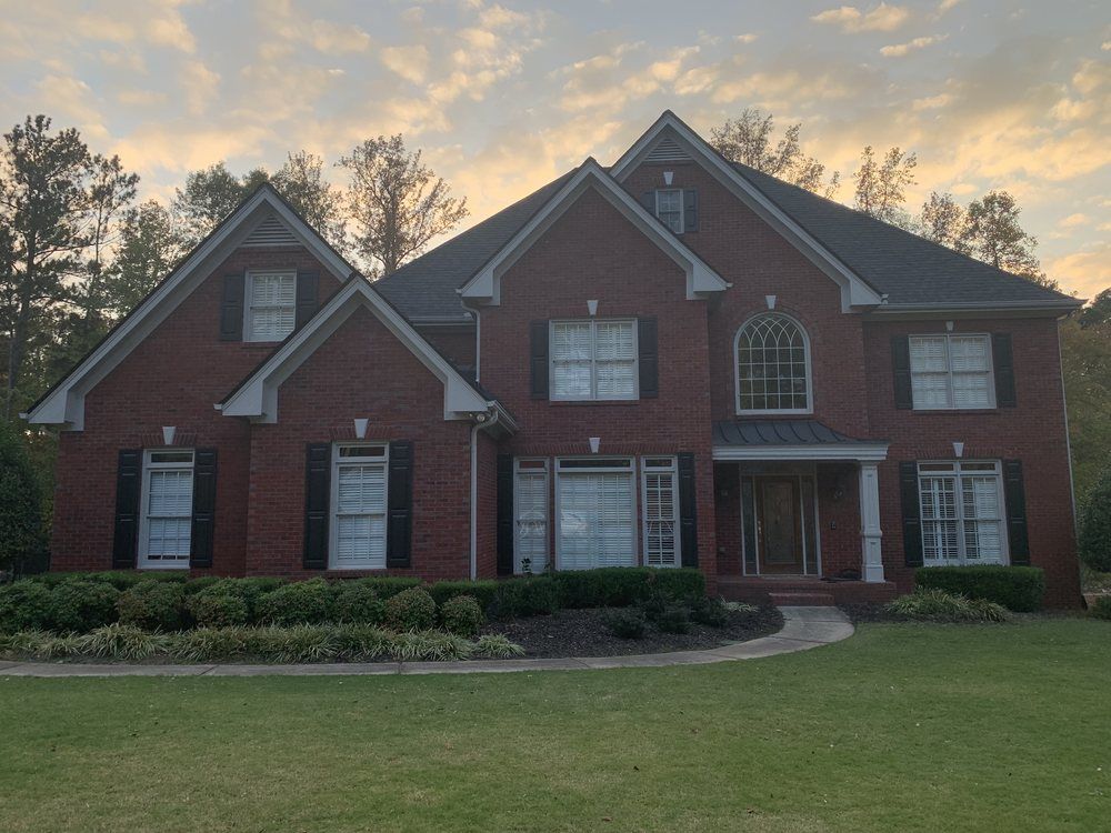 Brick two-story with a new roof at sunset