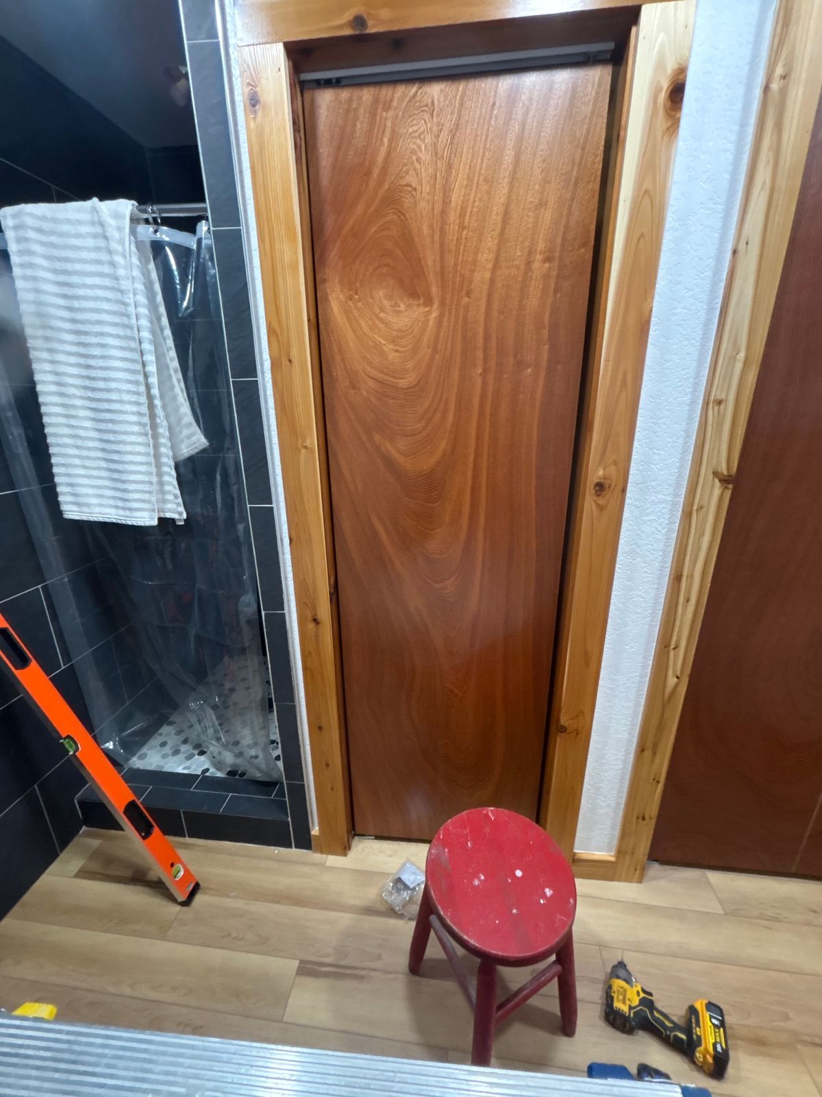 Bathroom mid-remodel with new tile and a wood door
