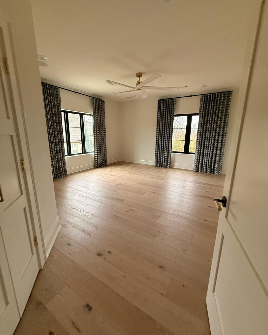 Empty bedroom with wood floors and clean windows after a move-out clean