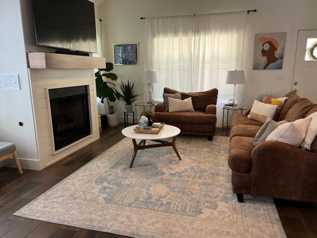 Living room with a fireplace and rug after a house cleaning