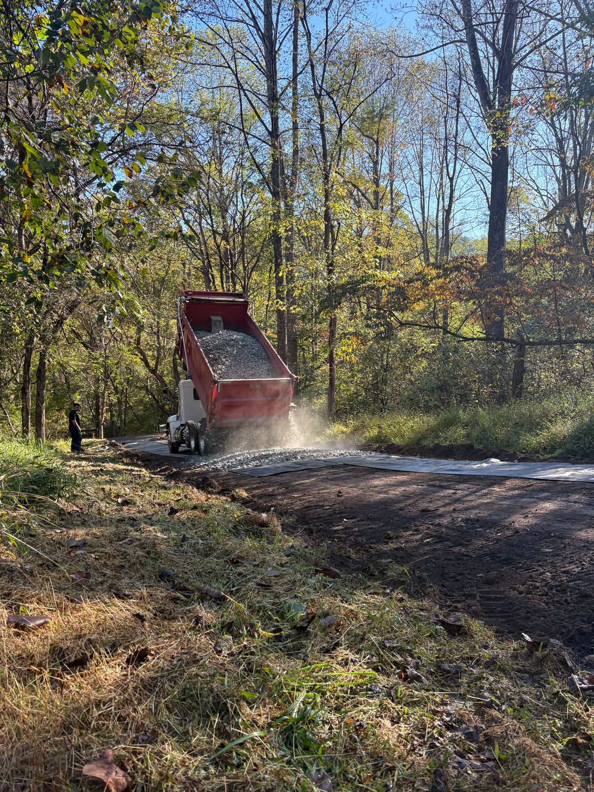 Dump truck spreading asphalt millings on a driveway