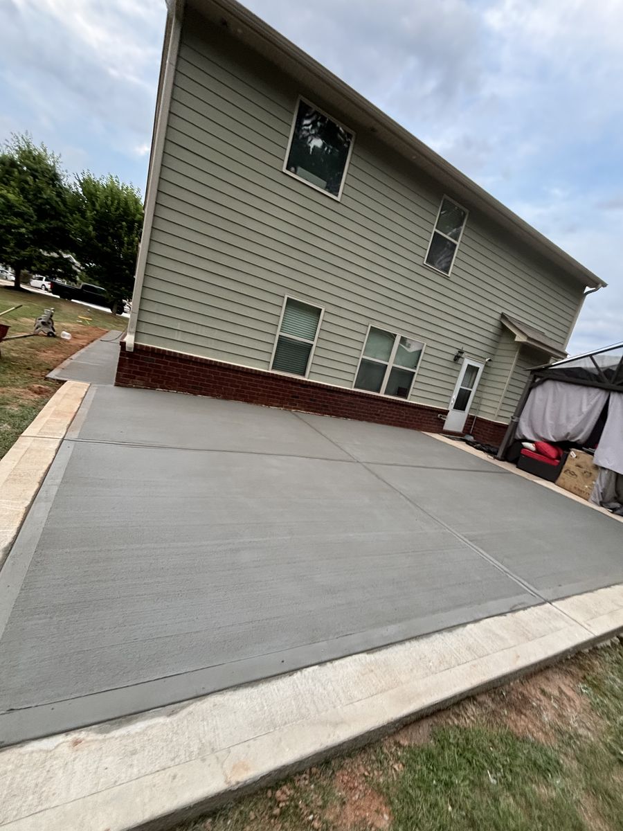 New residential concrete driveway and walkway alongside a home