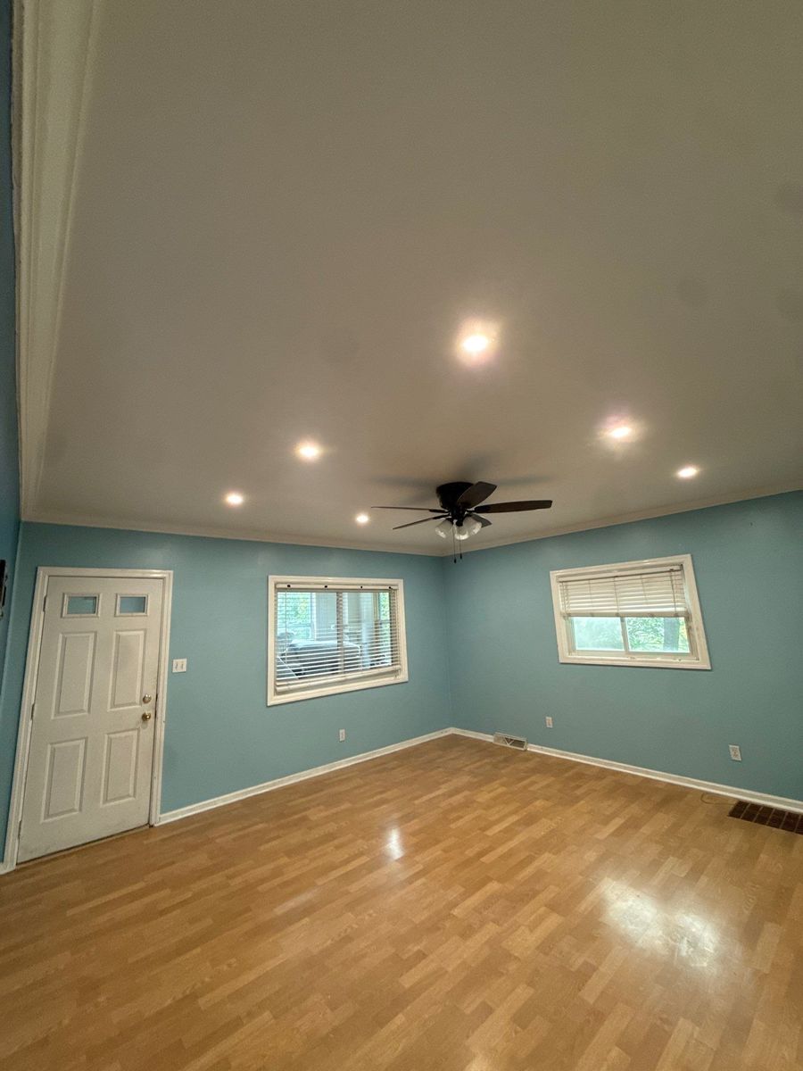 Renovated living room with new flooring and recessed lighting