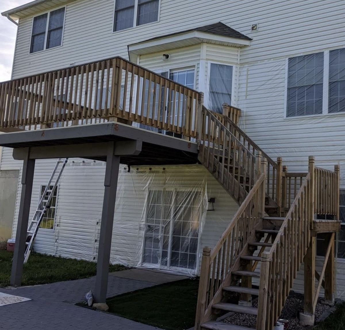 Deck stairs and railing in bare, unfinished wood before staining