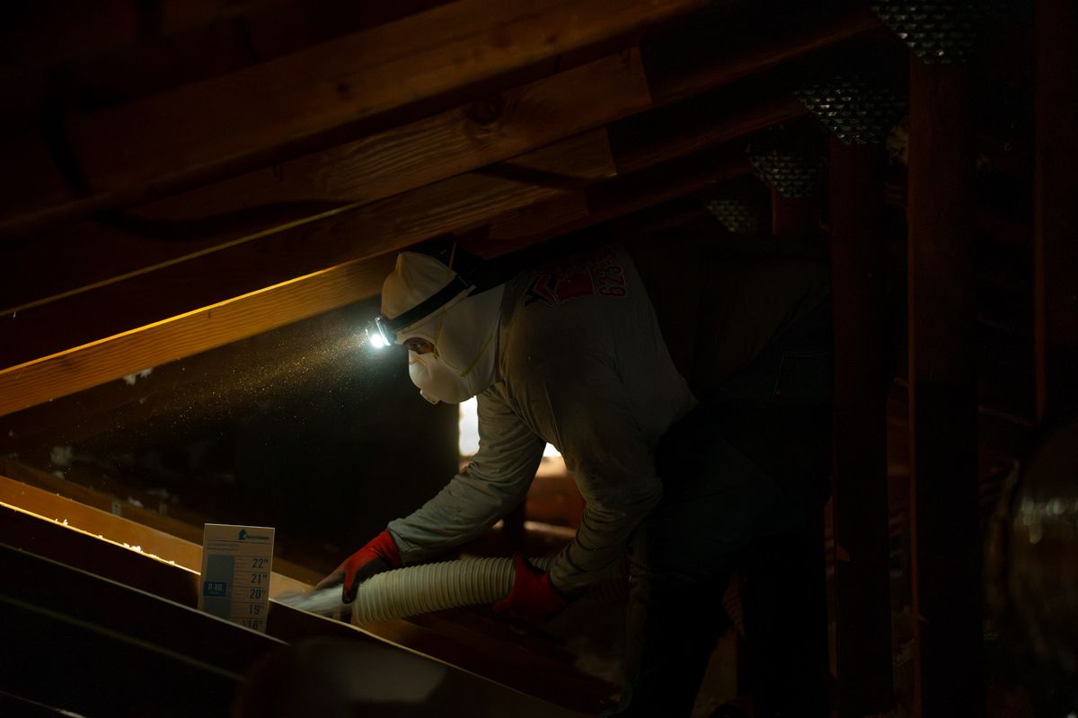 Foam Pro technician in a respirator and headlamp working in a dark Phoenix attic
