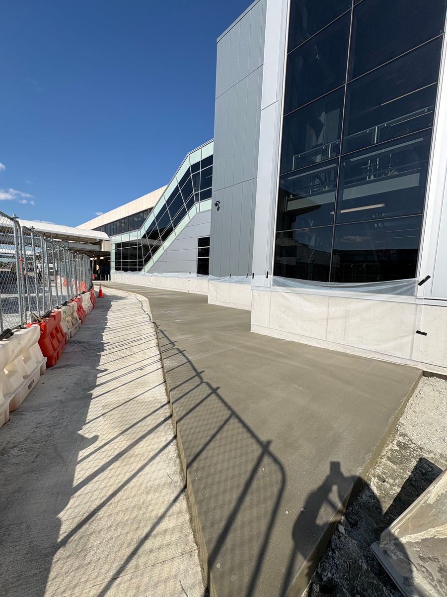 Commercial concrete sidewalk finished along a new glass office building