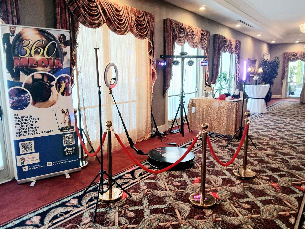360 booth with red carpet and gold stanchions set up in an elegant ballroom