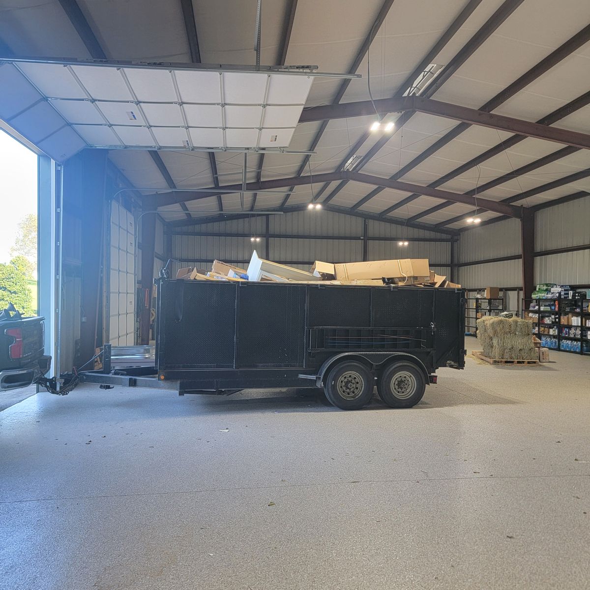 Loaded black dump trailer inside a large warehouse