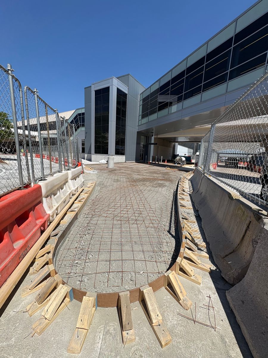 Curved radius sidewalk with wooden forms set before the pour at an airport terminal