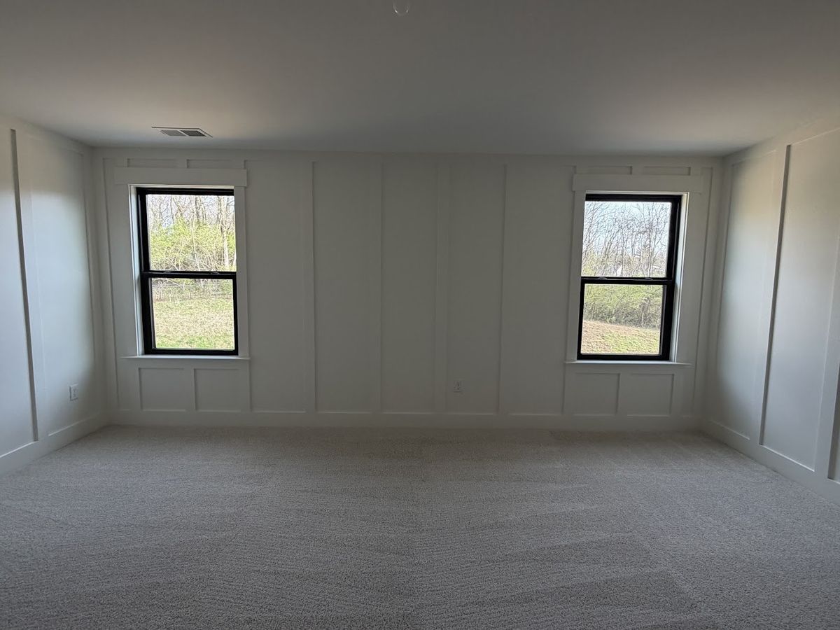 White board and batten feature wall with black-framed windows in a carpeted upstairs room