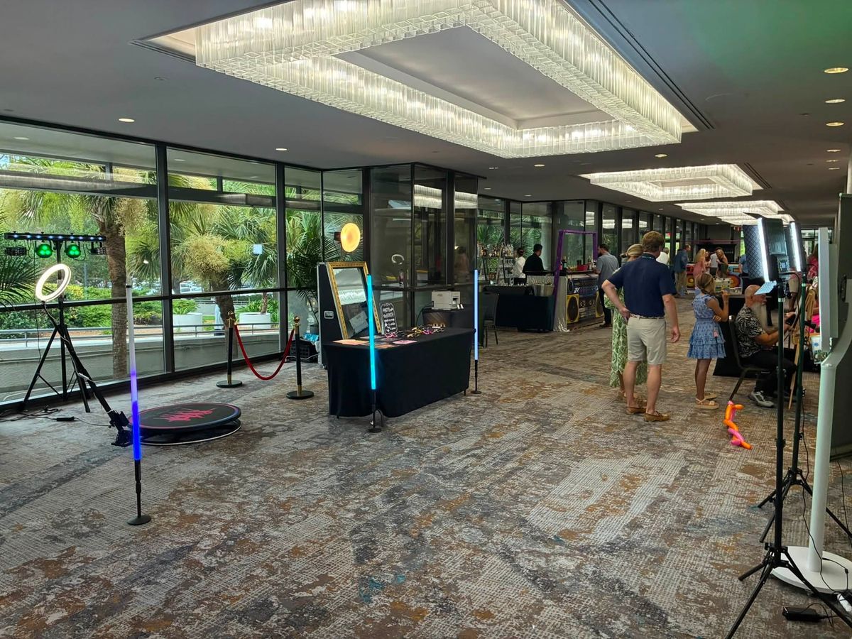 360 booth and selfie booth set up in a hotel event space under crystal chandeliers