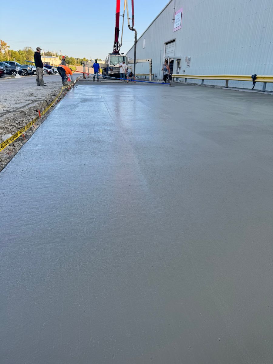 Pump truck placing concrete on a warehouse apron