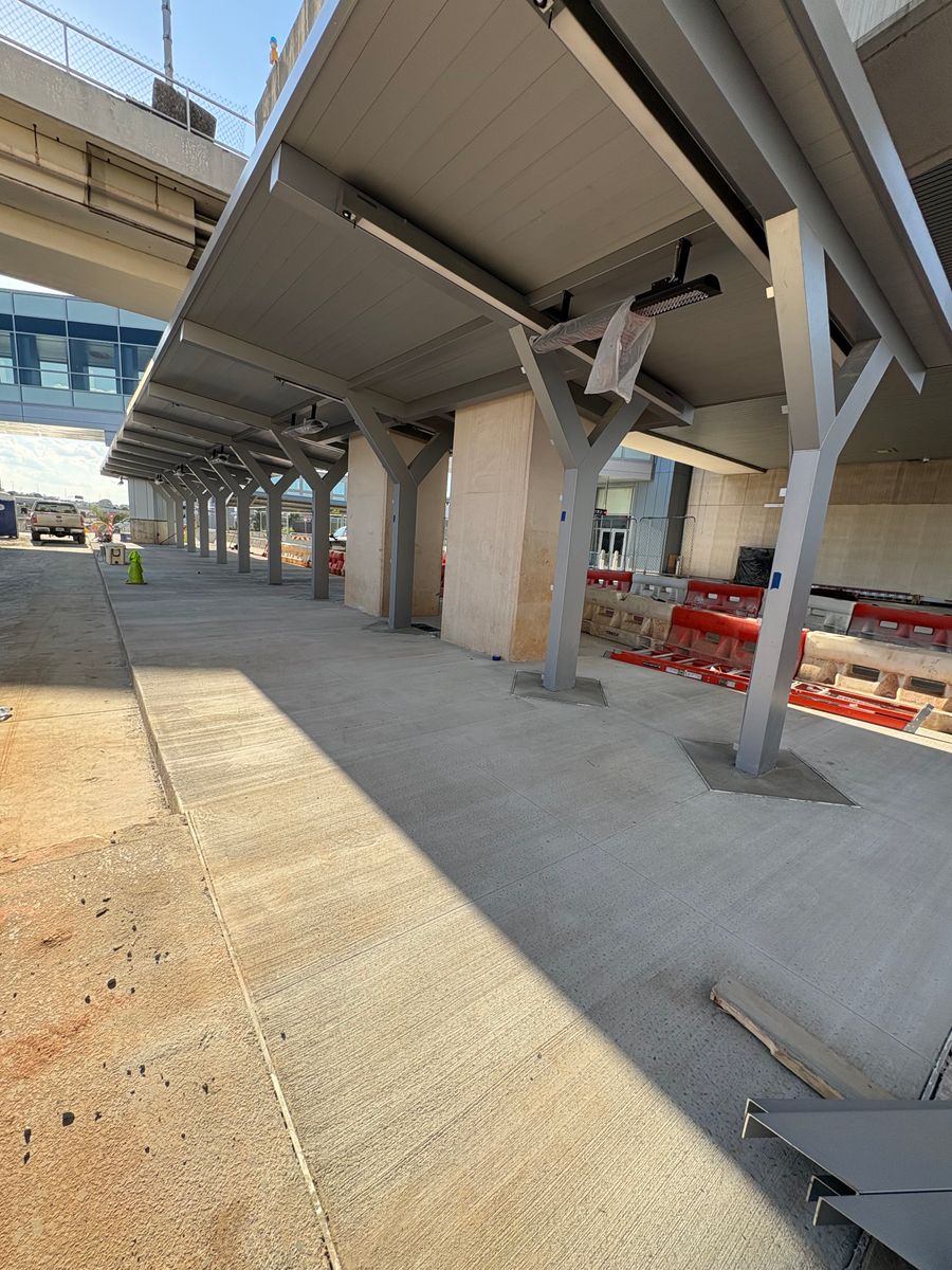 Finished concrete flatwork beneath a terminal canopy structure