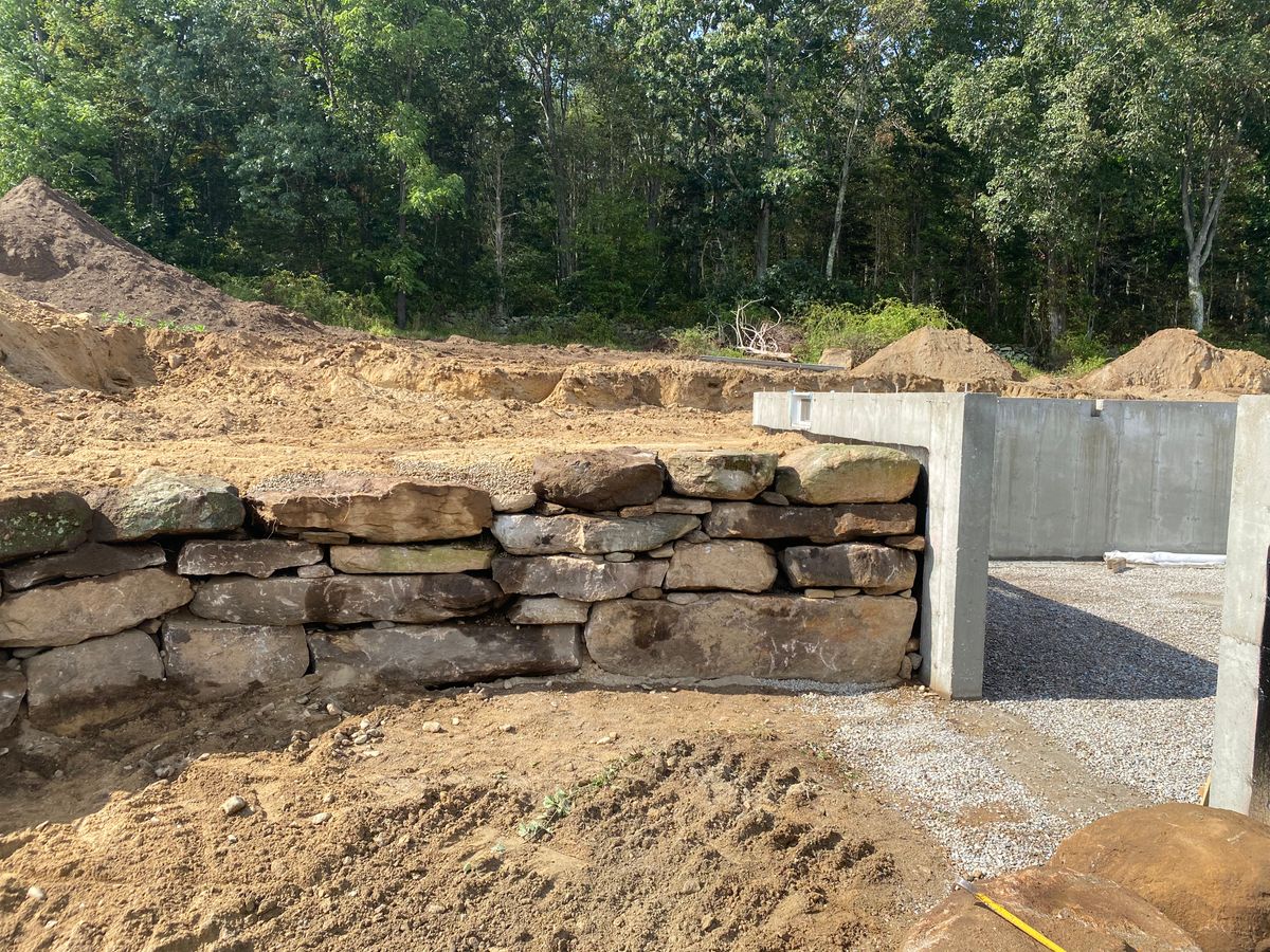 Machine set stone retaining walls for DArcy  Cleveland & Sons Excavation LLC in Pawcatuck, CT