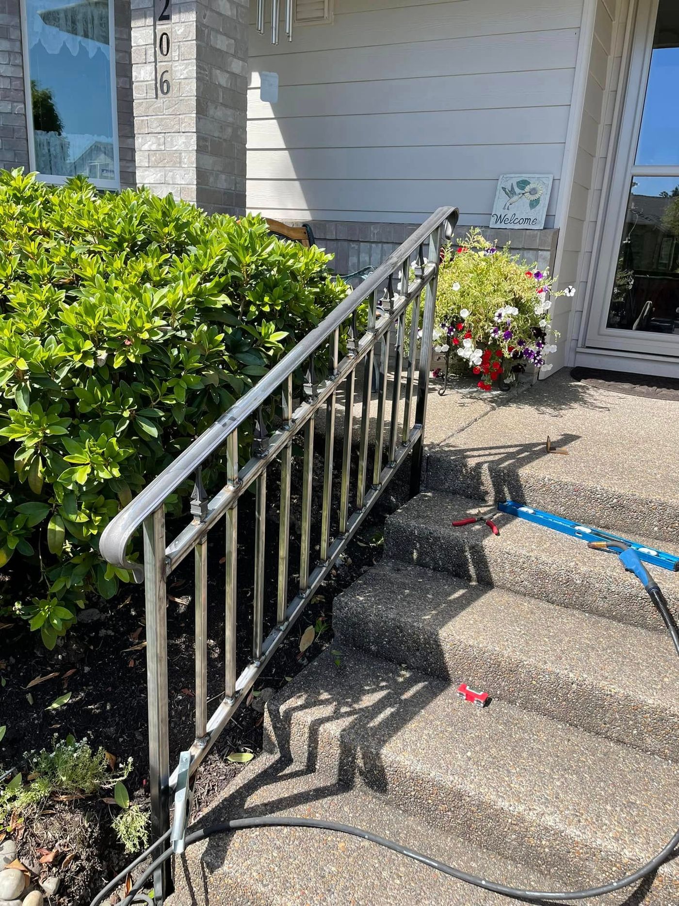 Black steel handrail installed on concrete front steps