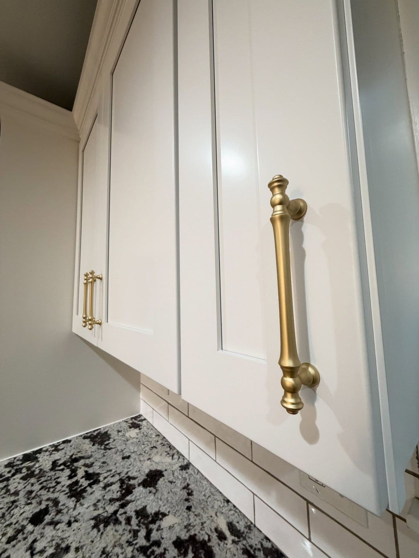 White Duck upper cabinets with brass pulls