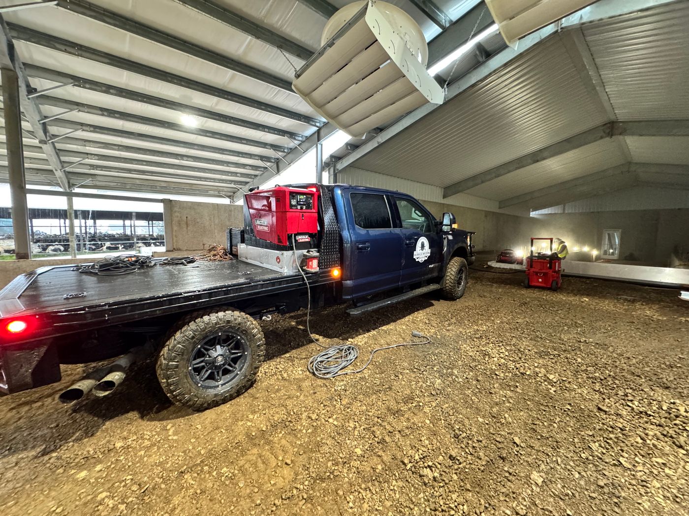 Valhalla Welding flatbed with the welder on the bed inside a pole barn